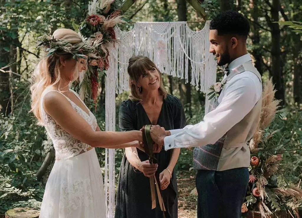 Sylvia directing a handfasting ceremony in a woodland setting